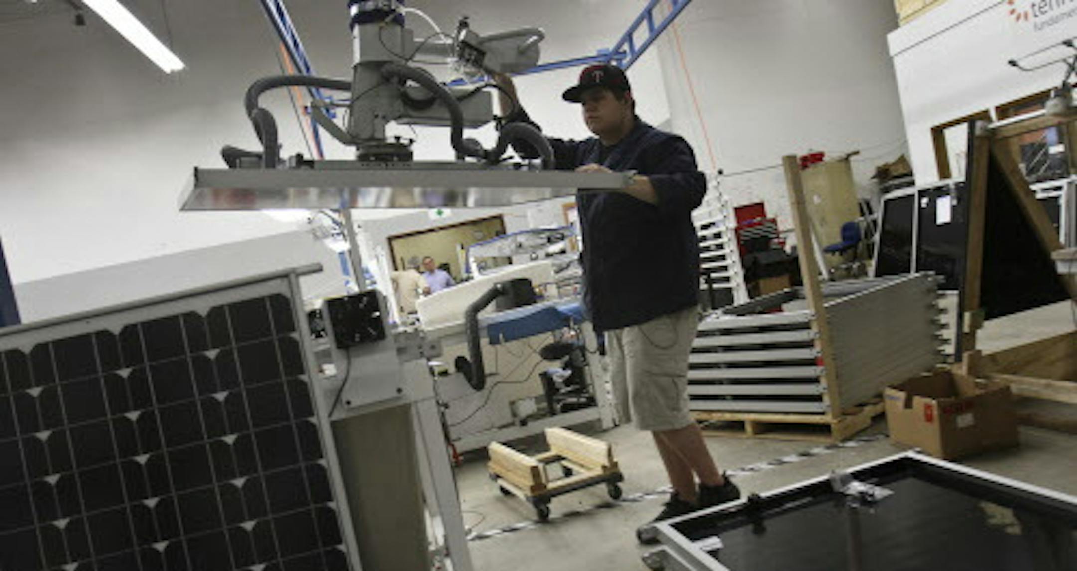 Colton Goodhart employee of tenkSolar guided a panel into place for a final power test to make sure that it meets certain specifications in Bloomington, Minn., Wednesday, September 7, 2011. ] (KYNDELL HARKNESS/STAR TRIBUNE) kyndell.harkness@startribune.com