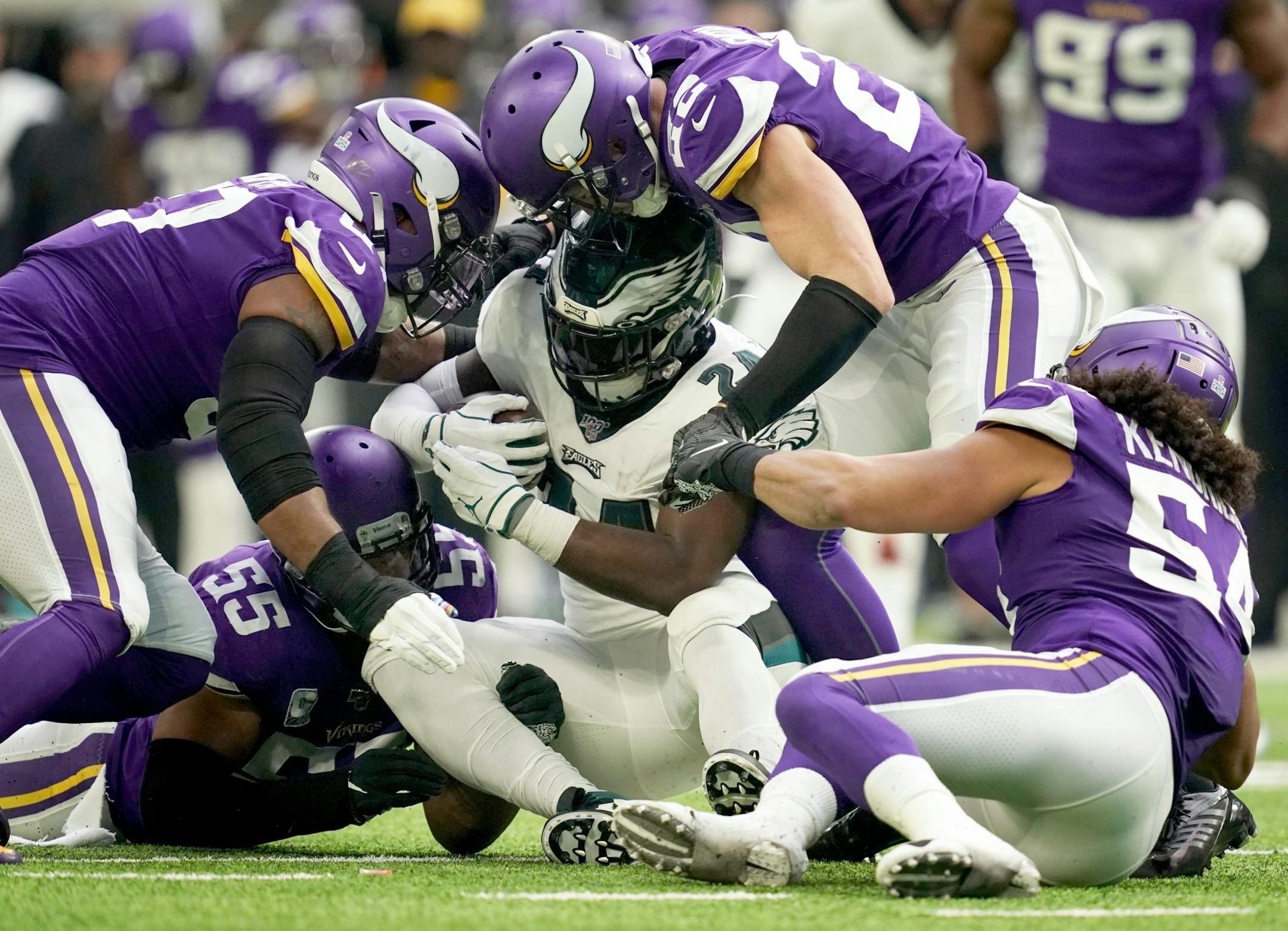 Philadelphia Eagles running back Jordan Howard (24) was brought down by Minnesota Vikings outside linebacker Anthony Barr (55) in the second quarter.