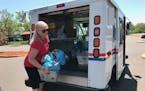 Terri Krysan, of Lakeville, pulls food donations from the back of a letter carrier truck during the Stamp Out Hunger event in Bloomington on Saturday,