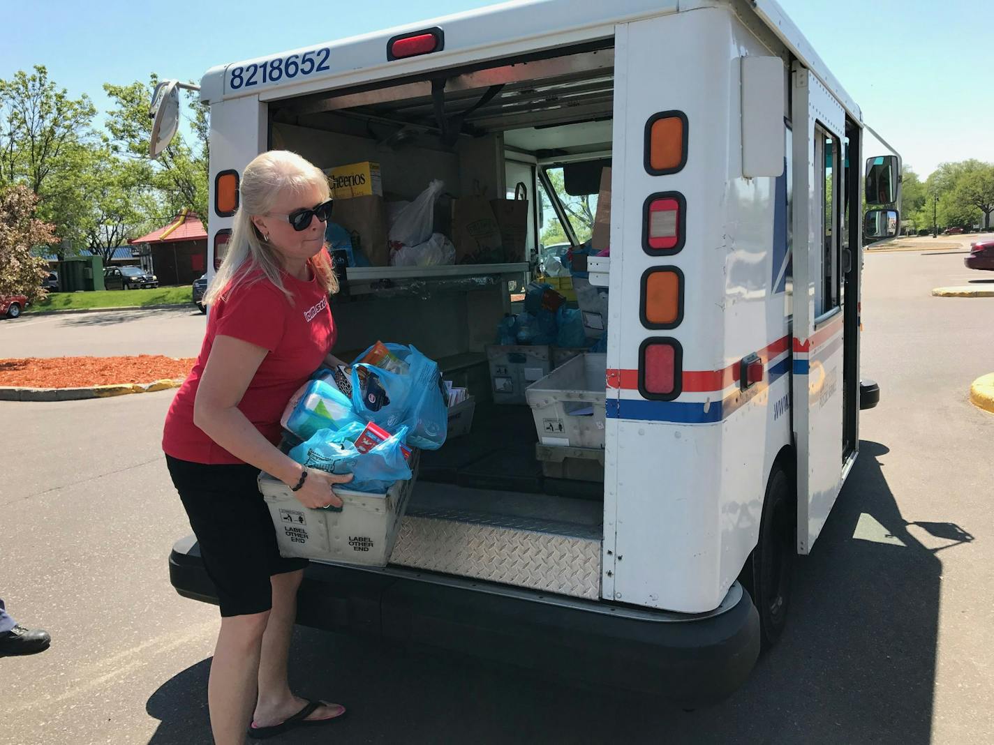 Terri Krysan, of Lakeville, pulls food donations from the back of a letter carrier truck during the Stamp Out Hunger event in Bloomington on Saturday, May 13.