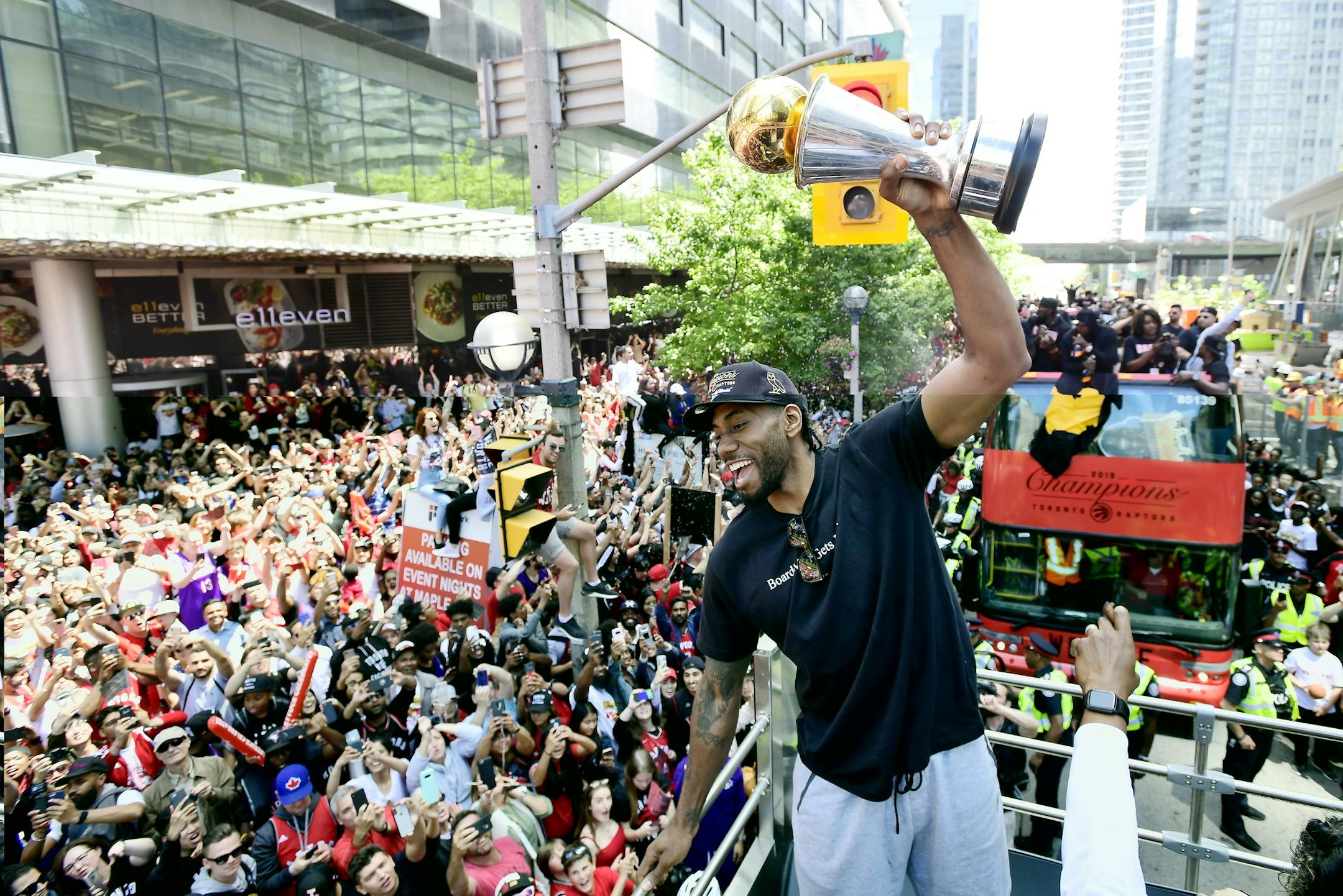 Toronto Raptors forward Kawhi Leonard hoists his playoffs MVP trophy during the NBA basketball championship team's victory parade in Toronto, Monday, June 17, 2019. (Frank Gunn/The Canadian Press via AP)