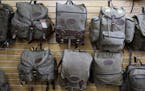 Waxed canvas packs hang on the wall at Frost River's Duluth store. The company has shifted production to face shields and other medical supplies to he