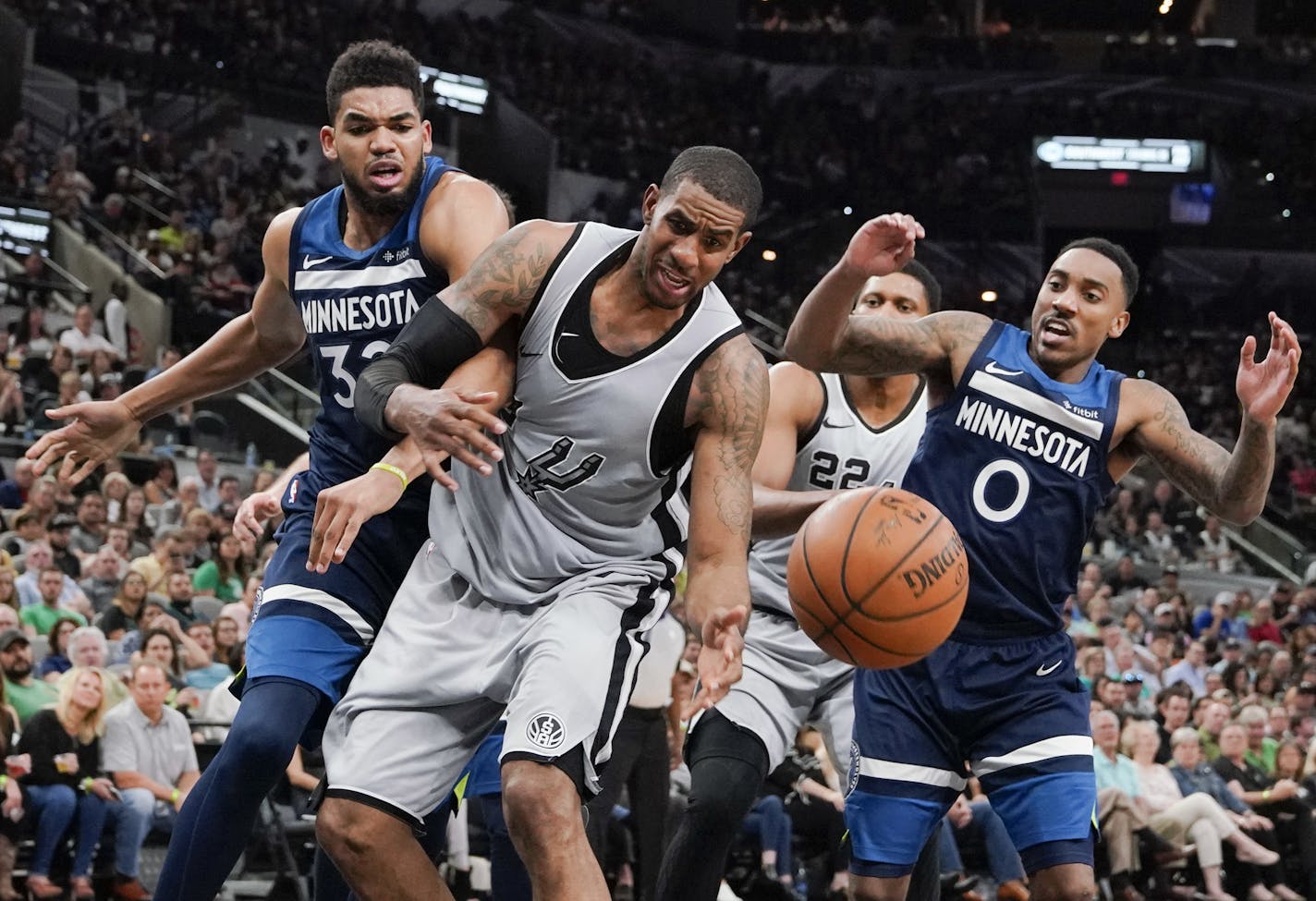 San Antonio Spurs forward LaMarcus Aldridge, center, fights for possession against Minnesota Timberwolves' Karl-Anthony Towns, left, and Jeff Teague during the second half of an NBA basketball game, Saturday, March 17, 2018, in San Antonio. San Antonio won 117-101. (AP Photo/Darren Abate)