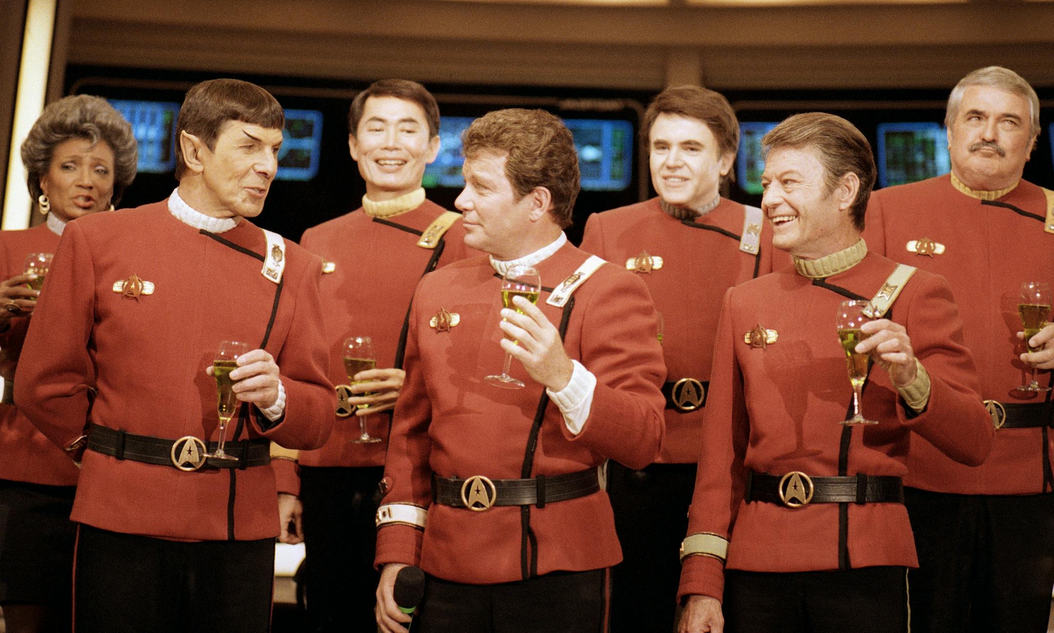 Members of the "Star Trek" crew, from right in front: DeForest Kelley, William Shanter and Leonard Nimoy, and back row from right: James Doohan, Walter Koenig, George Takei and Nichelle Nichols, toast the newest "Trek" film--in which Shanter makes his directorial debut--"Star Trek V: The Final Frontier," during a news conference Dec. 28, 1988 at Paramount Studios to announce the latest voyage. (AP Photo/Bob Galbraith) ORG XMIT: APHS107070