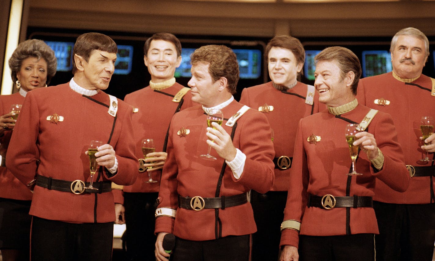 Members of the "Star Trek" crew, from right in front: DeForest Kelley, William Shanter and Leonard Nimoy, and back row from right: James Doohan, Walter Koenig, George Takei and Nichelle Nichols, toast the newest "Trek" film--in which Shanter makes his directorial debut--"Star Trek V: The Final Frontier," during a news conference Dec. 28, 1988 at Paramount Studios to announce the latest voyage. (AP Photo/Bob Galbraith) ORG XMIT: APHS107070