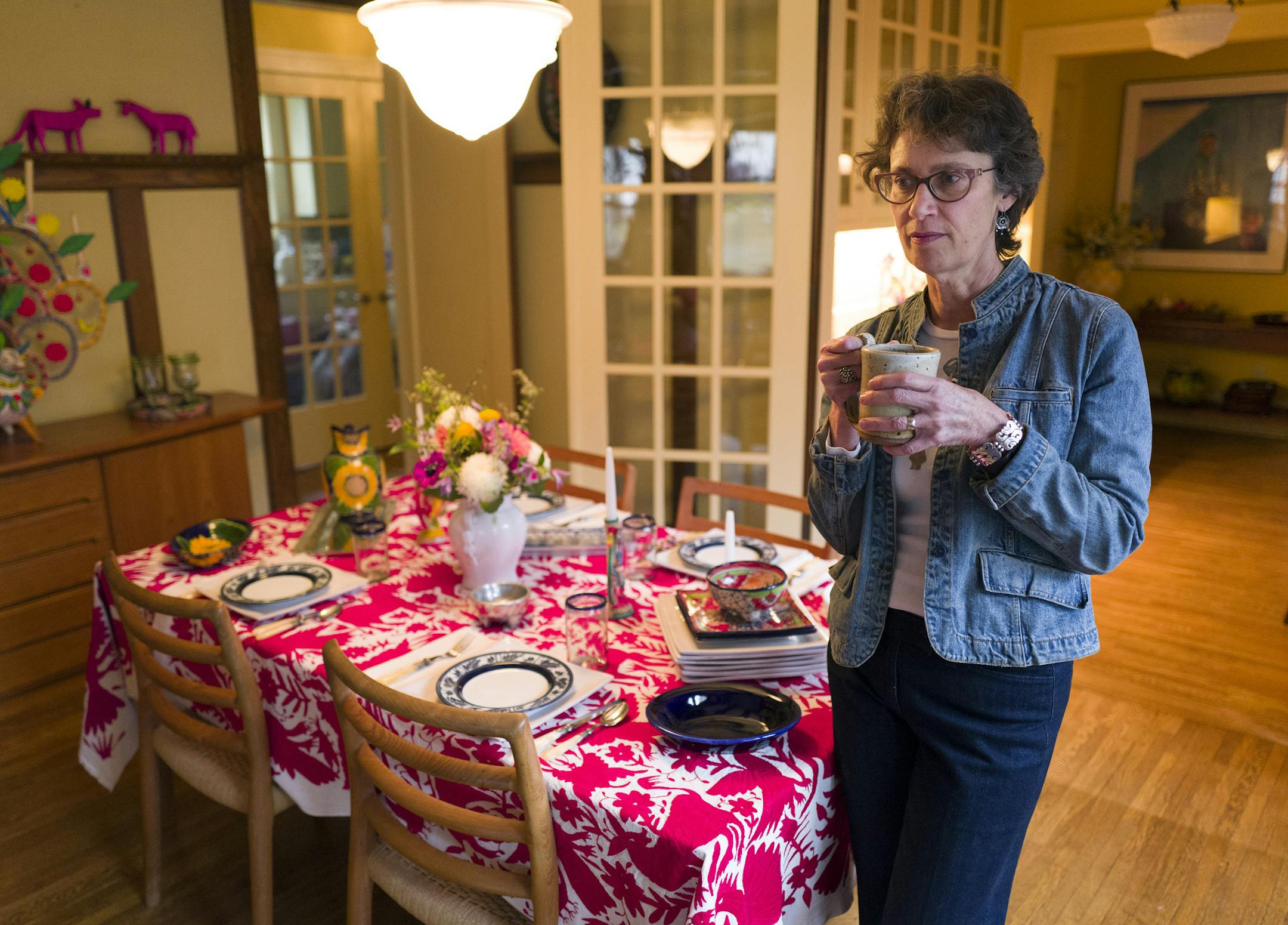 Anne Damon, owner of Zinnia Folk Arts in Minneapolis, sets a festive table with hand-embroidered linens and handpainted ceramics she’s collected on her many trips to Mexico.