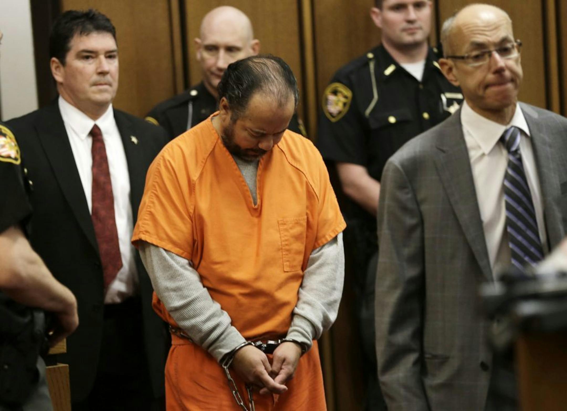 Ariel Castro, center, enters the courtroom for his arraignment Wednesday, June 12, 2013, in Cleveland. Castro, accused of holding three women captive in his Cleveland home for about a decade, pleaded not guilty Wednesday to hundreds of charges, including rape and kidnapping. He is charged with kidnapping three women and keeping them _ sometimes restrained in chains _ along with a 6-year-old girl he fathered with one of them.