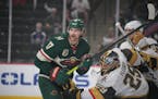 Vegas Golden Knights goalie Marc-Andre Fleury (29), right, tries to defend the goal from Minnesota Wild left wing Marcus Foligno (17) during the first