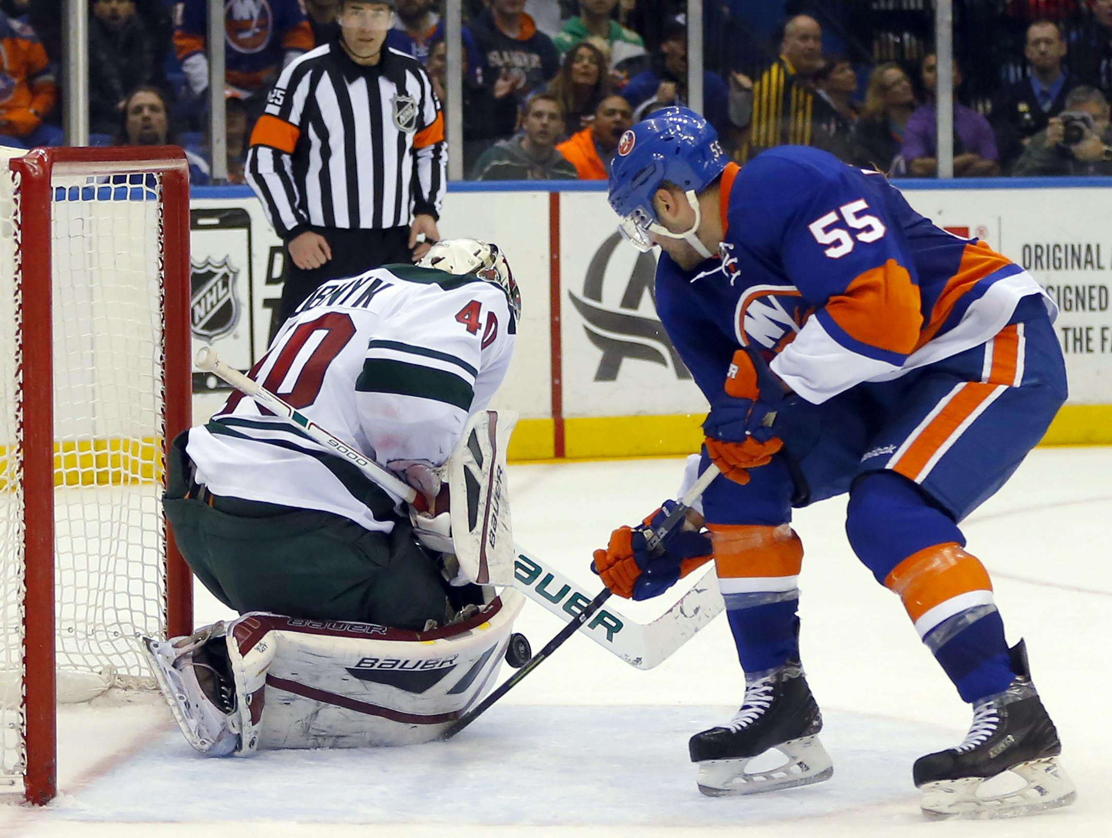 Minnesota Wild goalie Devan Dubnyk (40) stops a shot on a breakaway by New York Islanders defenseman Johnny Boychuk (55) during overtime in an NHL hockey game Tuesday, March 24, 2015, in Uniondale, N.Y. Minnesota won 2-1 in a shootout. (AP Photo/Paul Bereswill)