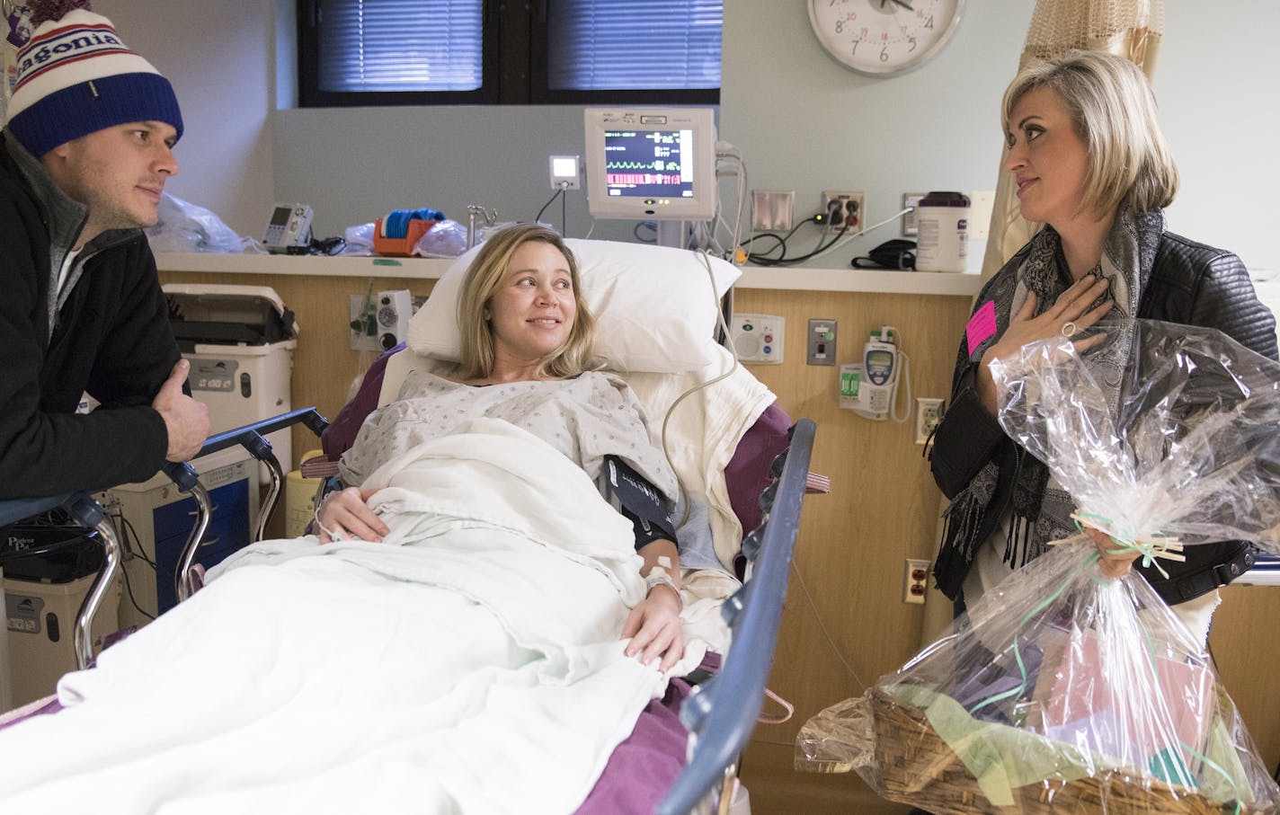 KARE 11 reporter Lindsey Seavert, with basket in hand, met with Jon and Jenny Tichich of Apple Valley in the antepartum unit at University of Minnesota Masonic Children's Hospital.