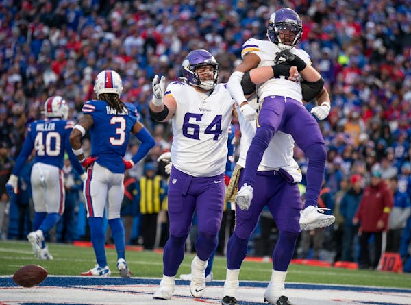 A Vikings offensive lineman lifted up Minnesota Vikings wide receiver Justin Jefferson (18) after he got the ball down to the 1-yard line late in the 