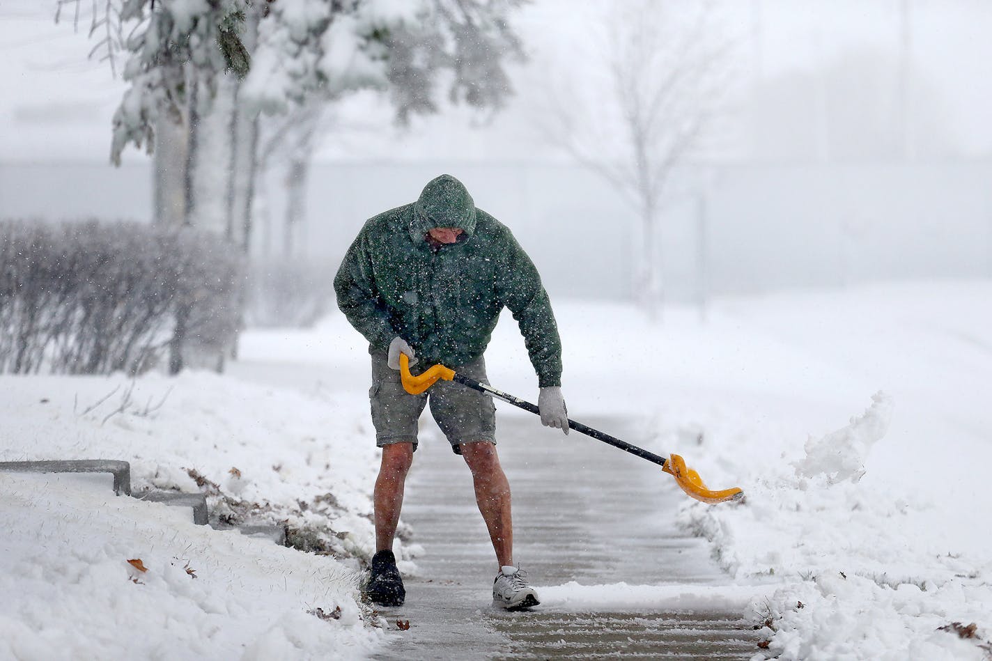 Peter Lidstone refused to give up on fall as he shoveled in shorts, Friday, November 18, 2016 in St. Cloud.