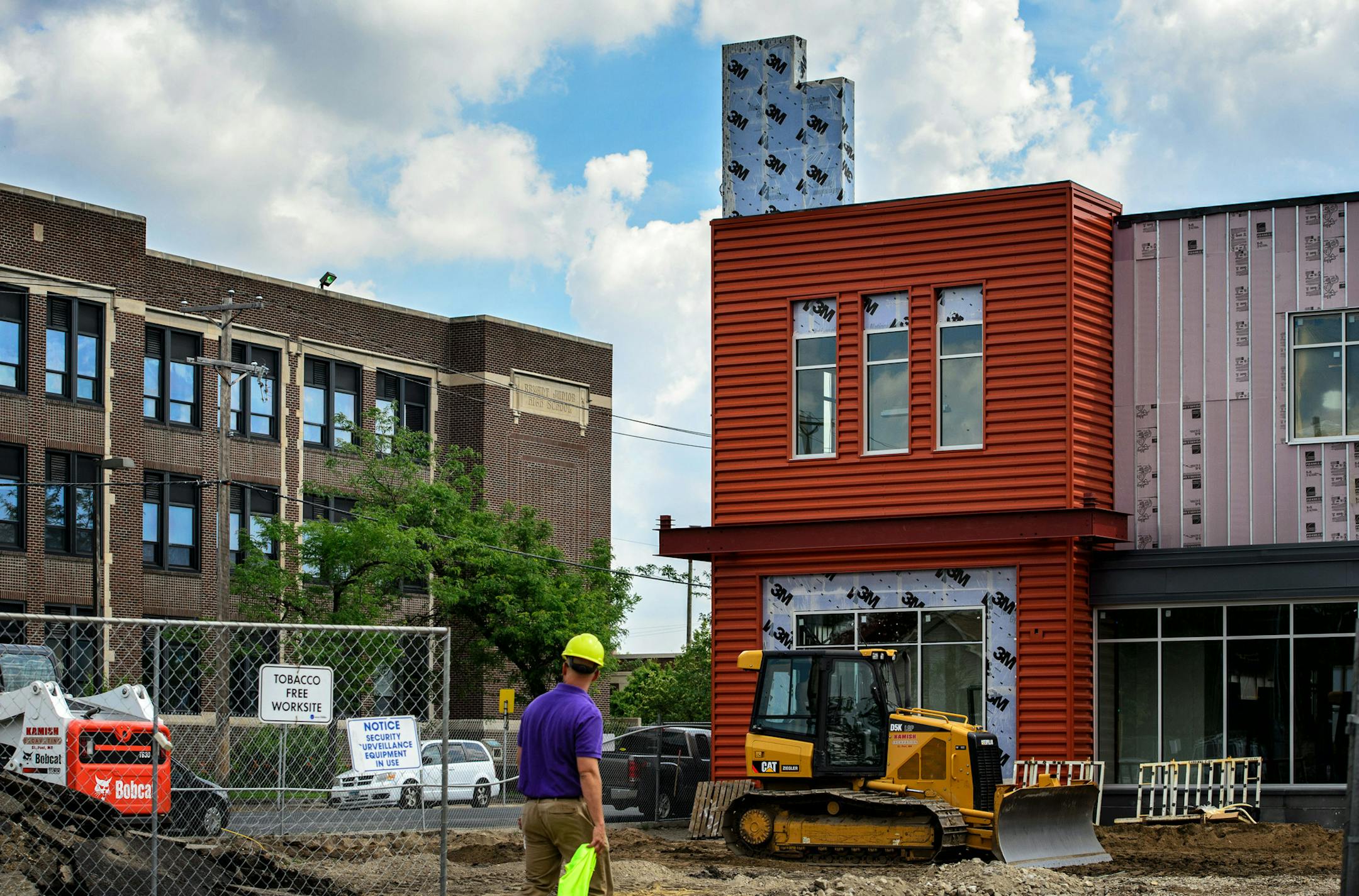 A new Seward Co-op is under construction at the corner of 38th Street and 3rd Ave S., Minneapolis, at right. Next door Anthony Theba hopes to turn an empty building into a bike shop and across the street, on left, is the Sabathani Center. ] GLEN STUBBE * gstubbe@startribune.com Friday, June 26, 2015 Anthony Theba is planning to open a bike shop to address racial equity issues in cycling in an old filling station near 35W on E. 38th Street. Across the street, a food co-op is betting with a multi-