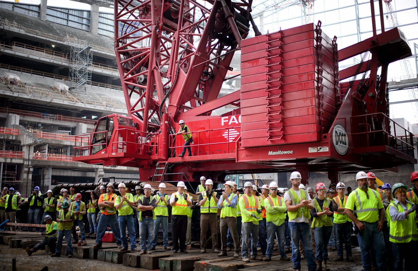 Stadium construction workers listened as speakers took to the stage. ] GLEN STUBBE * gstubbe@startribune.com Thursday September 16, 2015 A "topping out" ceremony for the new Minnesota Vikings stadium, marking the highest or last piece of steel placed on a building. Mark Wilf and Lt. Gov. Tina Smith were there. Heavy rain and lightening in the area made it unsafe to hoist the steel beam to the roof. Workers were treated to a free pork chop lunch. ORG XMIT: MIN1509171414050046