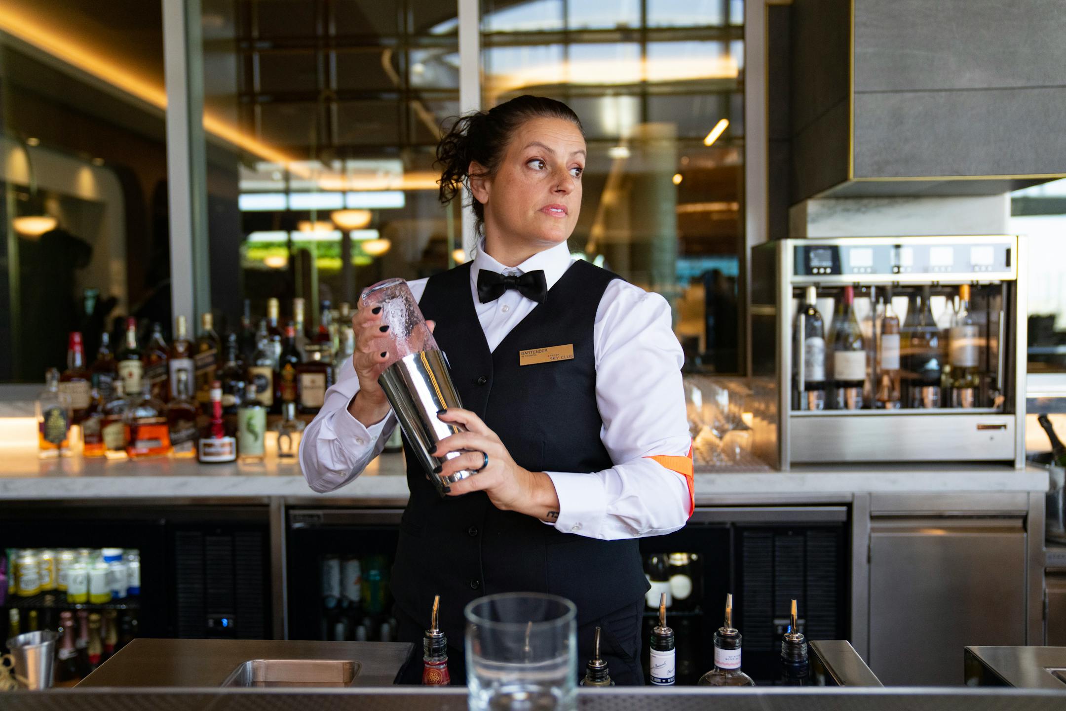 Danny Baideme, a bartender at the new Delta Sky Club mixes drinks during an open house press preview.
