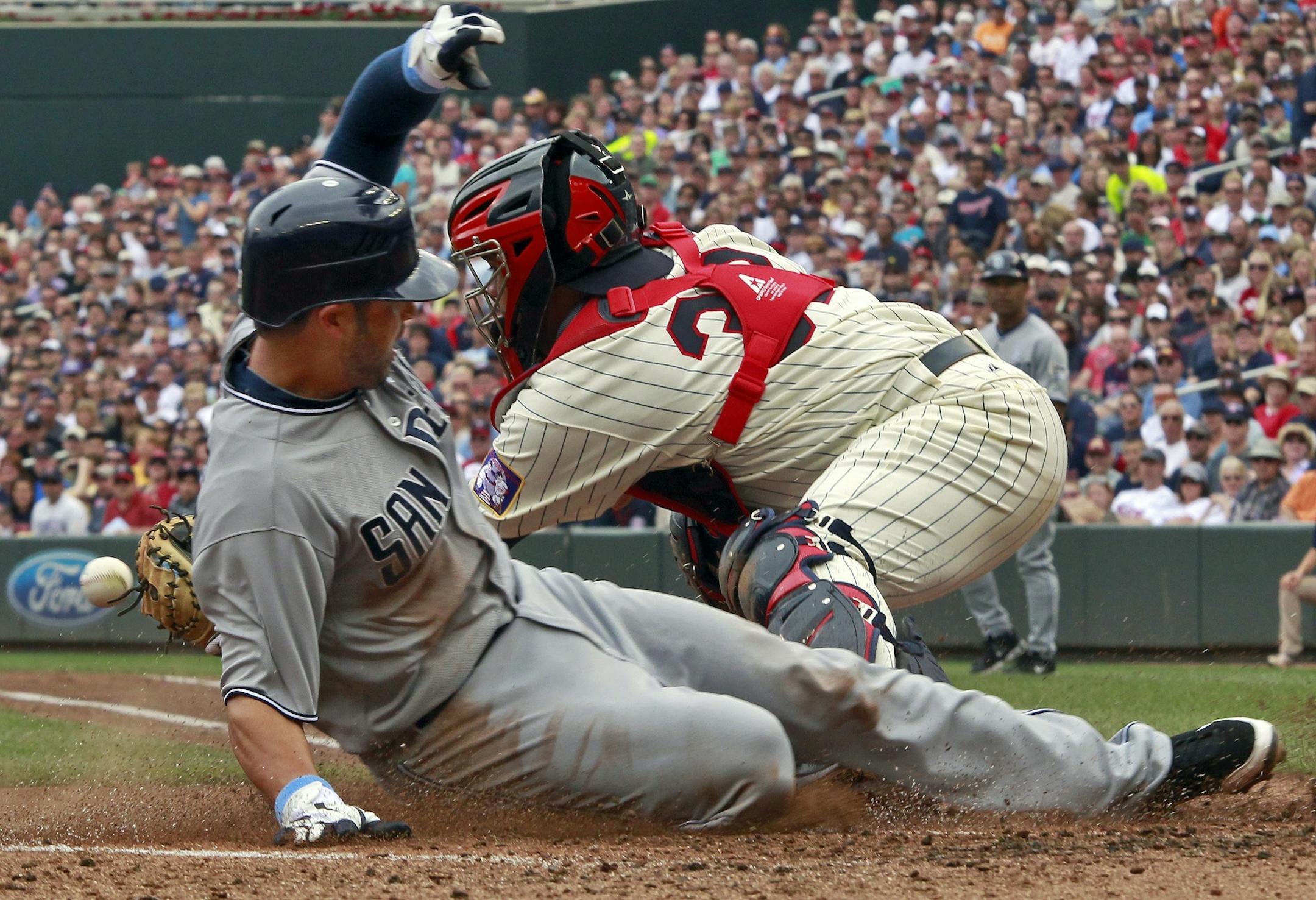 Padres Jason Bartlett was safe at home beating the throw to Twins catcher Rene Rivera in 4th inning action. The play tied the score at 1-1.