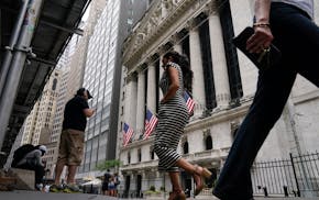 Pedestrians walk past the front of the New York Stock Exchange in New York, Tuesday, June 14, 2022. Wall Street is wobbling between gains and losses T