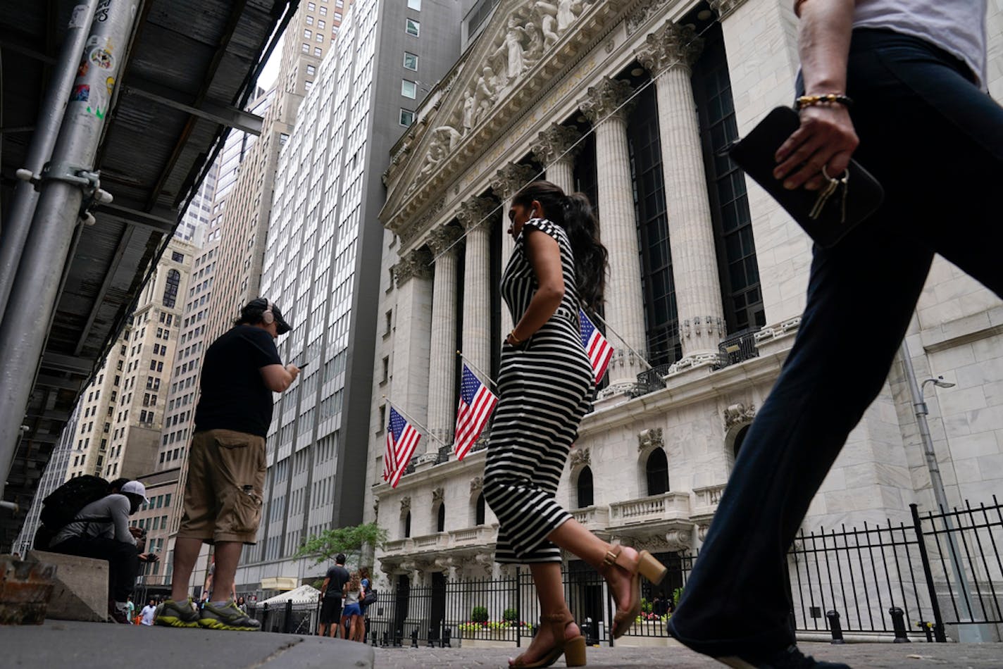 Pedestrians walk past the front of the New York Stock Exchange in New York, Tuesday, June 14, 2022. Wall Street is wobbling between gains and losses Tuesday in its first trading after tumbling into a bear market on worries about a fragile economy and rising rates. (AP Photo/Seth Wenig)