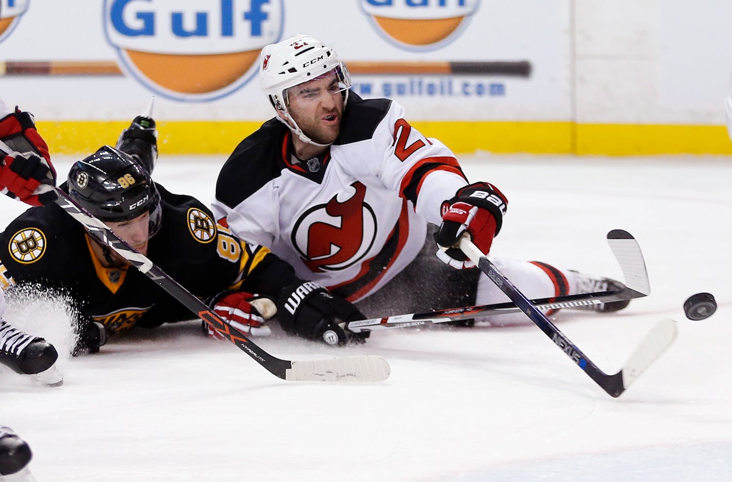 New Jersey Devils' Kyle Palmieri (21) battles Boston Bruins' Kevan Miller (86) for the puck during the third period of an NHL hockey game in Boston, Sunday, Dec. 20, 2015. The Bruins won 2-1 in a shootout.(AP Photo/Michael Dwyer)