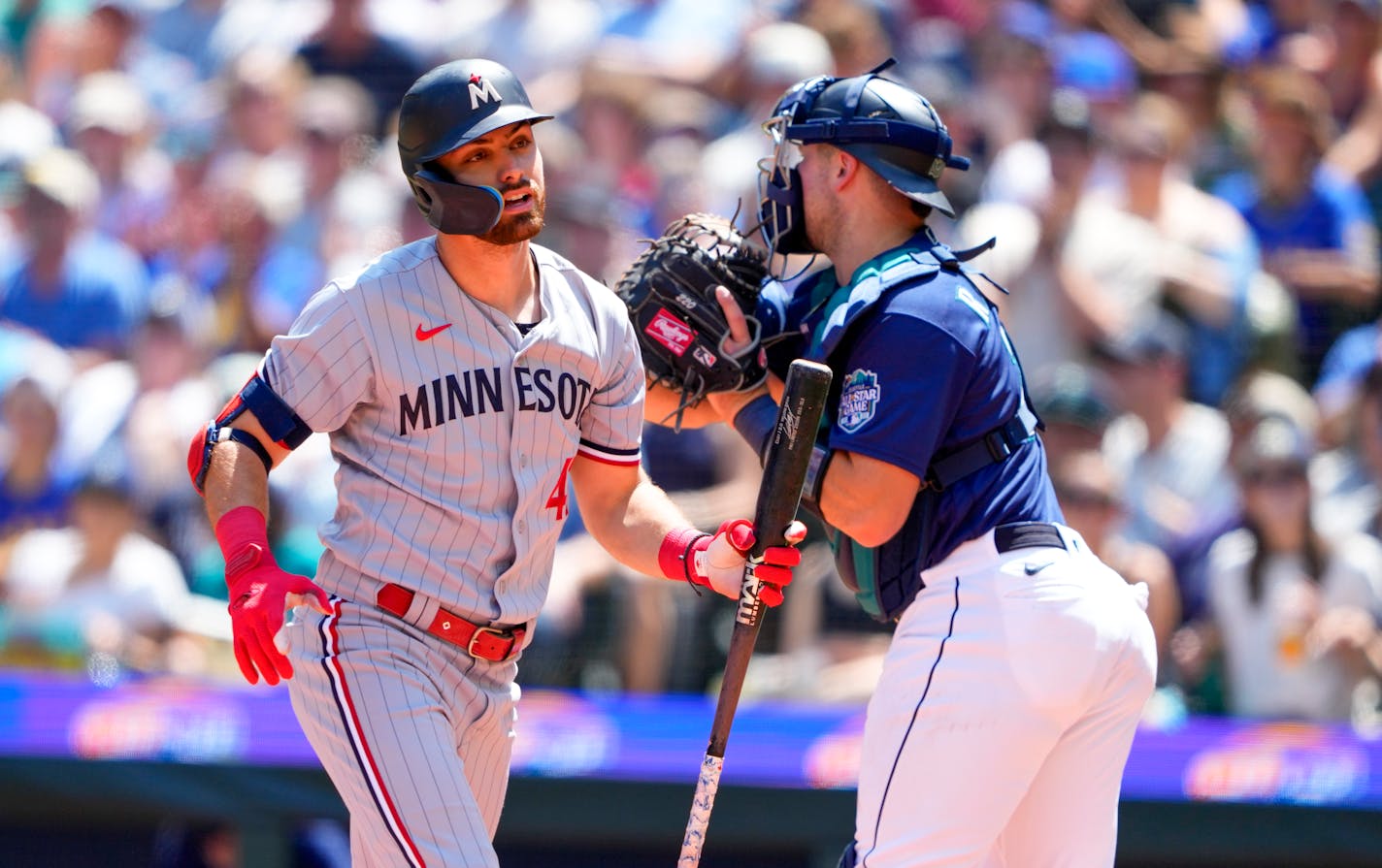 Minnesota Twins' Edouard Julien reacts after striking out as Seattle Mariners catcher Cal Raleigh throws the ball back to the mound during the third inning of a baseball game, Thursday, July 20, 2023, in Seattle. (AP Photo/Lindsey Wasson)