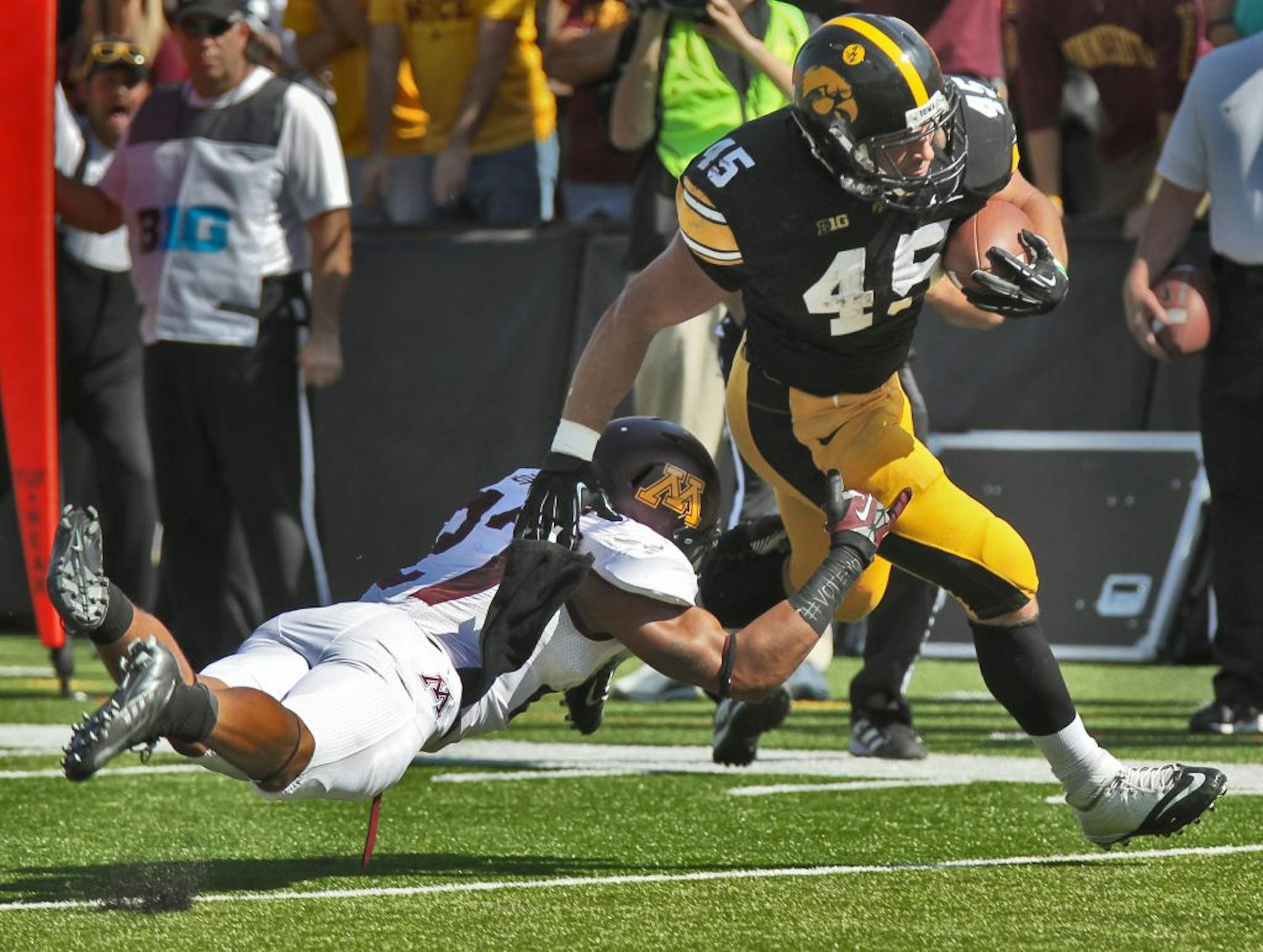 Iowa running back Mark Weisman broke through the tackle of Minnesota's Cedric Thompson to score a touchdown in first half action.