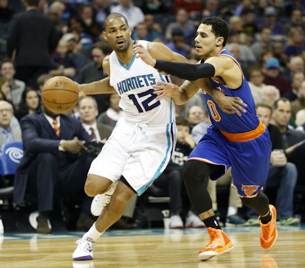 Charlotte Hornets guard Gary Neal, left, looks for room to pass against New York Knicks guard Shane Larkin in the first half of an NBA basketball game