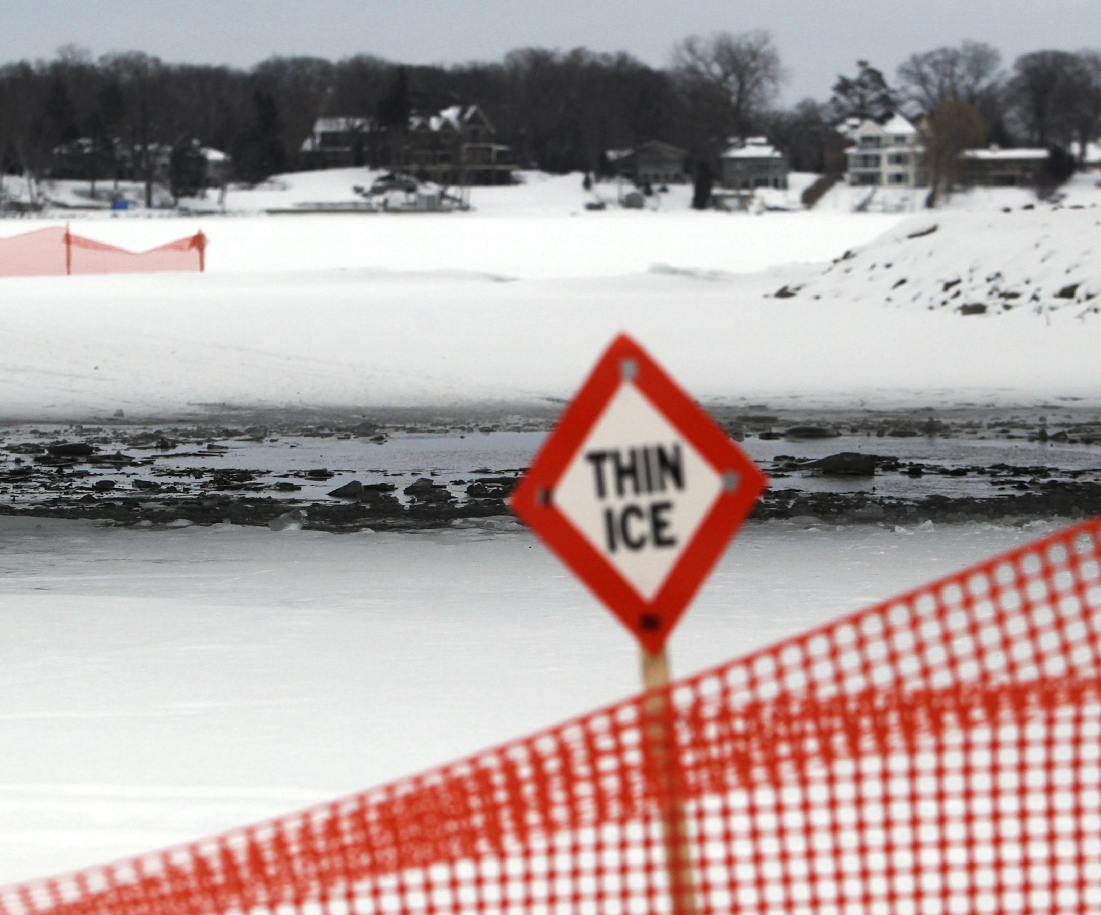 Orange fencing and signs surround an area of thin ice on Black Lake underneath Interlachen Road Thursday, Feb. 7, 2013, in Spring Park, MN.] (DAVID JOLES/STARTRIBUNE) djoles@startribune.com Hennepin County is trying to make Lake Minnetonka thin ice warnings more eye-catching by stretching orange snow fencing around warning signs. Sheriff's deputies and volunteers also are at public launch sites talking to people before they go out on the lake.