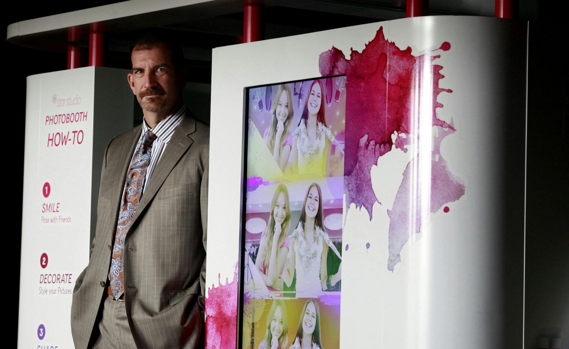 Coinstar chief financial officer Scott Di Valerio shows one of the company's new Star Studio Photobooths in May 2012, in Bellevue, Wash. The company, which runs its namesake coin counting machines and Redbox movie rental kiosks, has rolled out new automated retail technology that allows consumers to get more done when visiting a store. (Erika Schultz/Seattle Times/MCT) ORG XMIT: 1140381