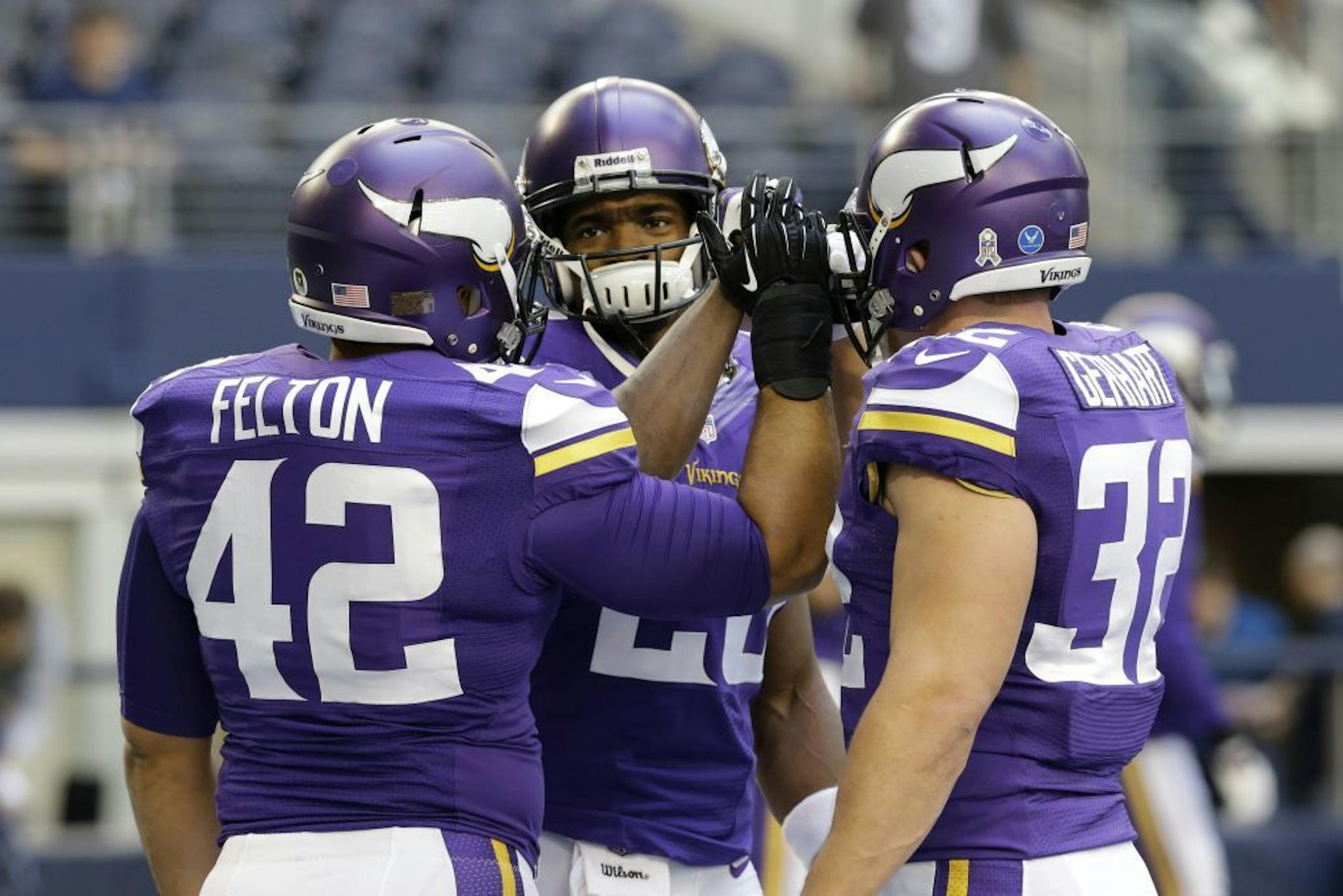 Minnesota Vikings running back Adrian Peterson, center, high-fives with Jerome Felton (42) and Toby Gerhart (32) during warm ups at an NFL football game against the Dallas Cowboys, Sunday, Nov. 3, 2013, in Arlington, Texas.
