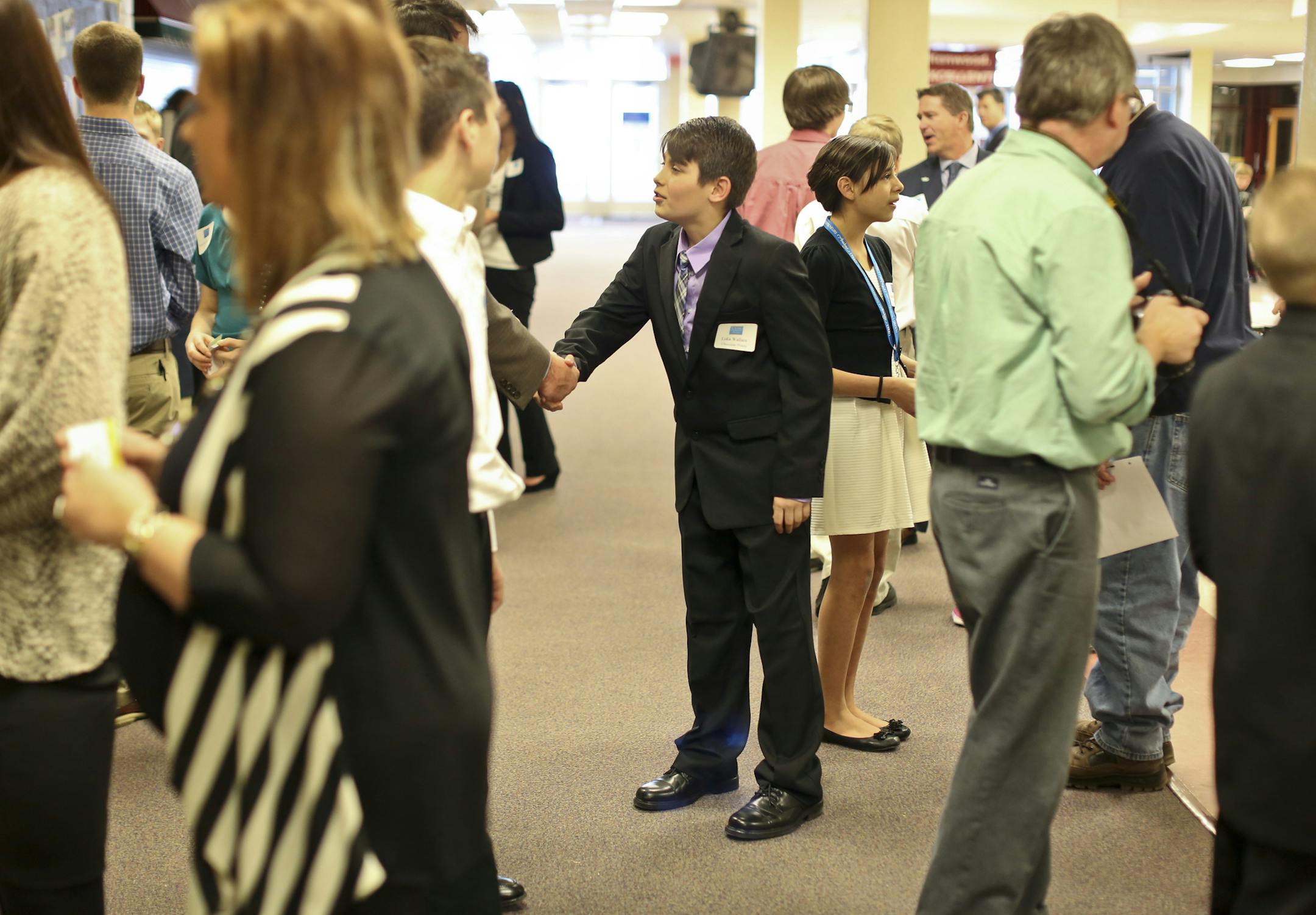 Luca Wallace introduced himself to an investor at a meet and greet before presenting at the Shark Tank Meets the Apprentice event at Kenwood Trail Middle School in Lakeville, Minn., on Wednesday, March 19, 2014. Wednesday the students in the Young Entrepreneurs Academy presented projects to a panel of Chamber of Commerce investors to obtain funding for their business. This is a national program but Lakeville is one of the first districts in the nation to have a collaborative program with their C