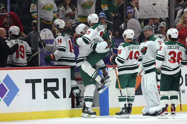 Wild defenseman Alex Goligoski jumps into the arms of left wing Marcus Foligno after Goligoski scored in overtime against the Hurricanes