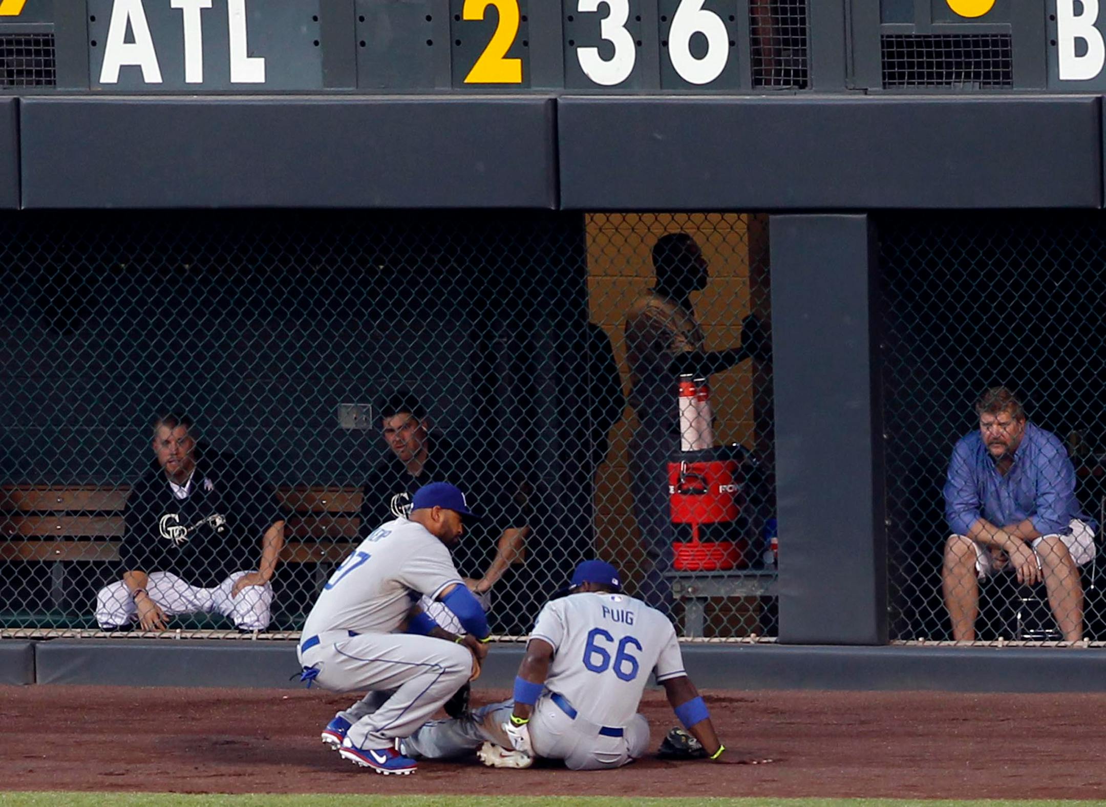 Los Angeles Dodgers right fielder Yasiel Puig (66) was checked by center fielder Matt Kemp after being injured when making a catch against the Colorado Rockies in the fifth inning Wednesday. Puig remained through the fifth inning but was then pulled because of a hip injury.