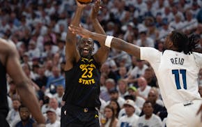 Golden State forward Draymond Green shoots over the arm of Timberwolves center Naz Reid in the second quarter Tuesday at Target Center.