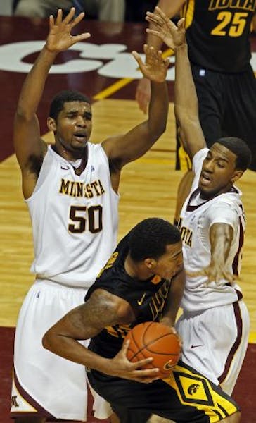]Minnesota's Ralph Sampson III, left and Austin Hollins put the defensive squeeze on Iowa's Jarryd Cole.