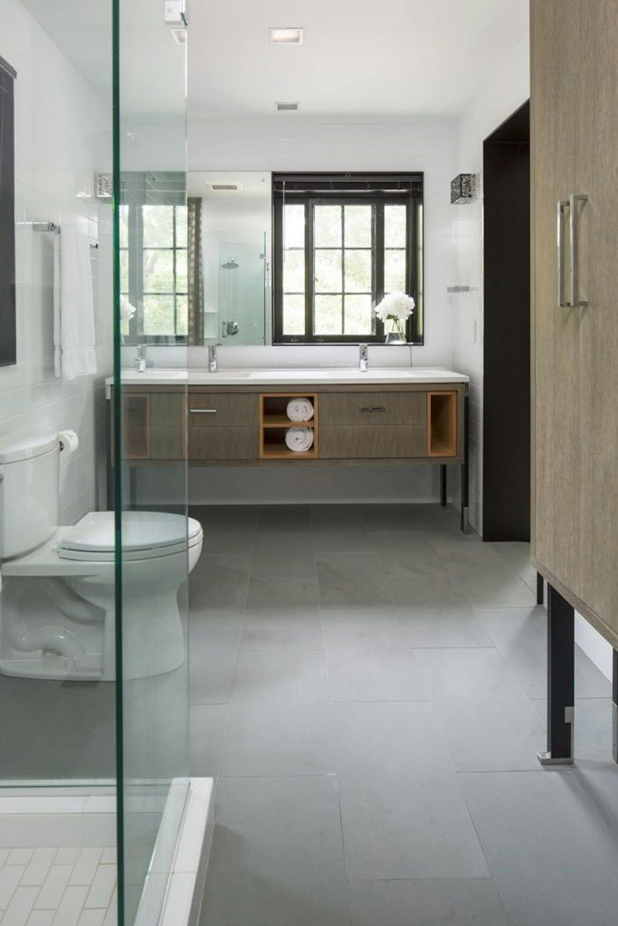 The new bathroom's cabinets and vanity are raised off the floor on black lacquered legs.