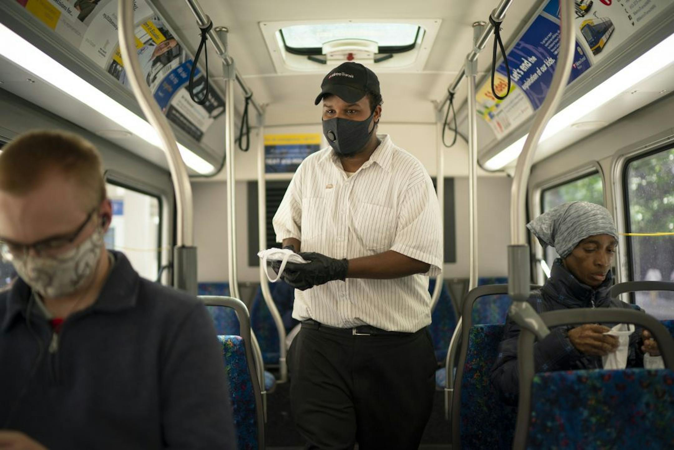 Metro Transit's Aweld Hussein offered free masks to riders of a Metro Transit bus stopped on the corner of 7th St. & Nicollet Thursday afternoon.