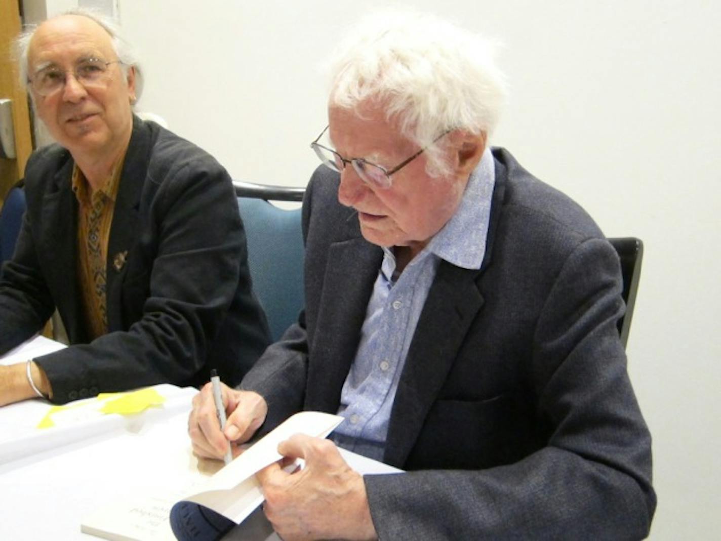 Thomas R. Smith and Robert Bly sign books after Tuesday's reading.