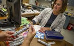 FILE-- Diane Voelker, a school nurse, and her assistant, Beth Little, look over EpiPens at Stone Bridge High School in Ashburn, Va., Aug. 31, 2012. In