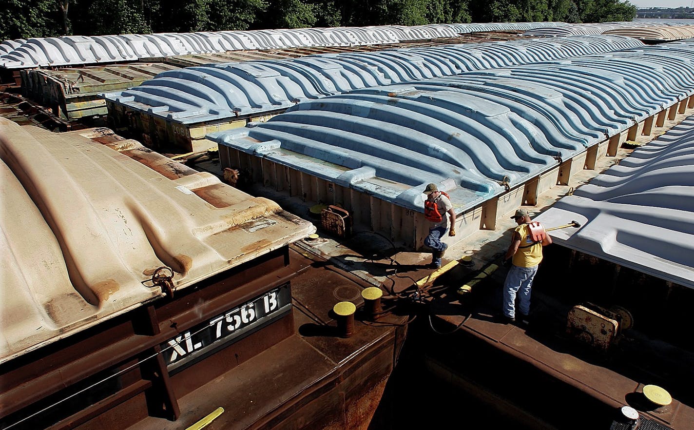 Towboat Senior Deckhand Al Davis, right, and Junior Deck Hand Randy Howard, left, work on securing barges they anchored earlier on Mississippi River the near Quincy, Ill., Monday, June 16, 2008. The barges which contain soybeans and corn will be anchored in the river until the flood waters recede. The Mississippi River is closed to barge traffic due to flood conditions that have destroyed homes and thousands of acres of corn and soybeans. (AP Photo/Seth Perlman)