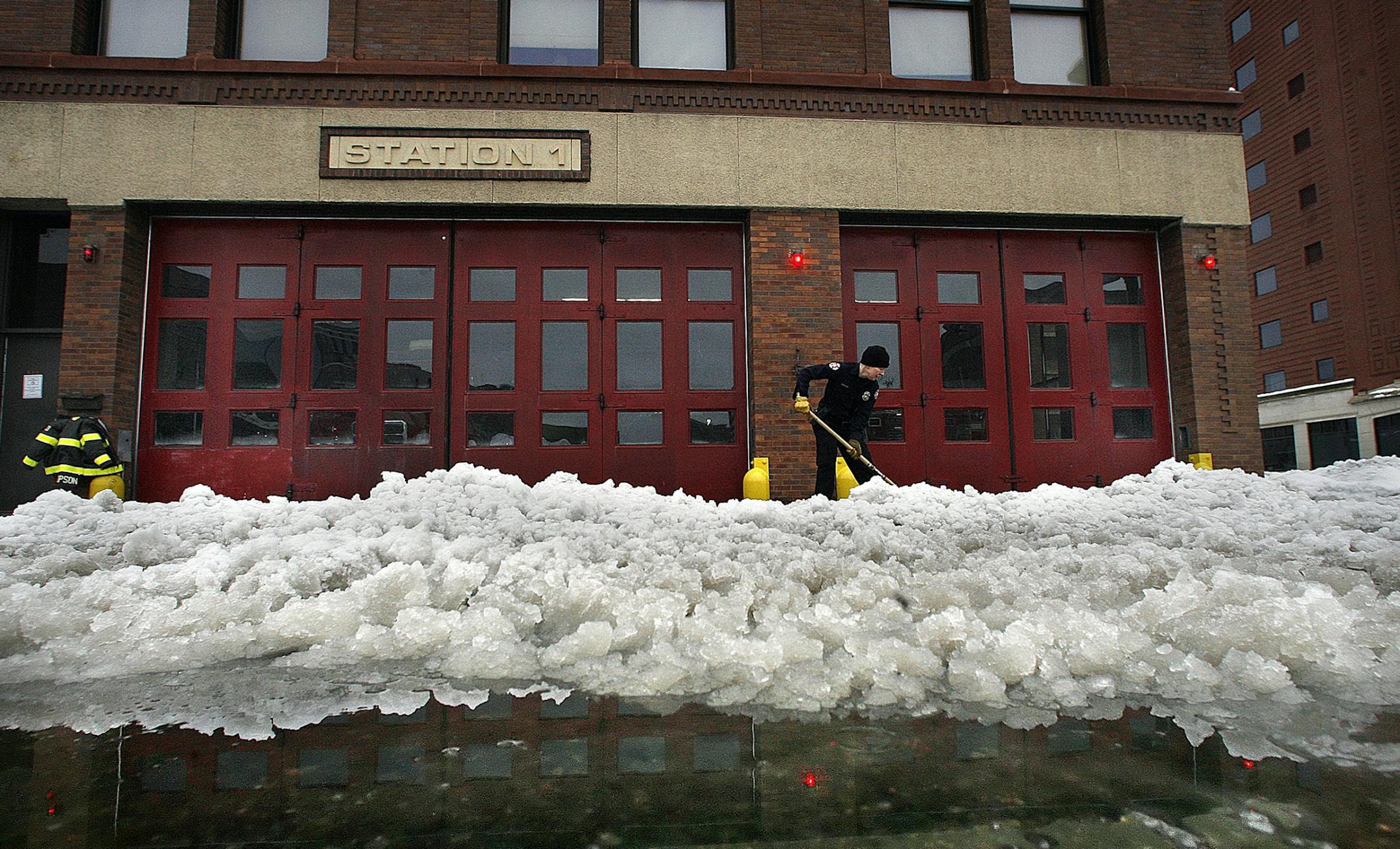 Fire motor operator Helena Thompson, 45, shoveled heavy, wet snow from the apron in front of Station #1 in downtown Minneapolis on Christmas Day. Thompson drives Engine #1.