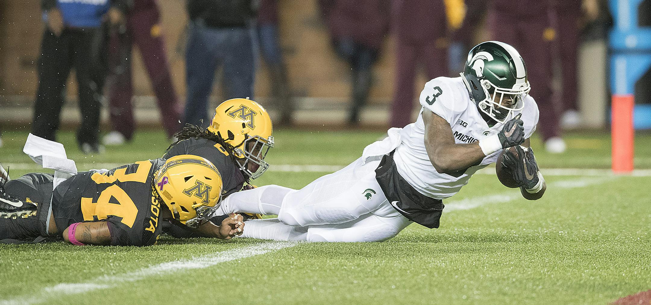 Michigan State's running back LJ Scott plowed through Minnesota's defensive back Antonio Shenault, left, and Duke McGhee during the second quarter as the Gophers took on Michigan State at TCF Bank Stadium, Saturday, October 14, 2017 in Minneapolis, MN. ] ELIZABETH FLORES ï liz.flores@startribune.com