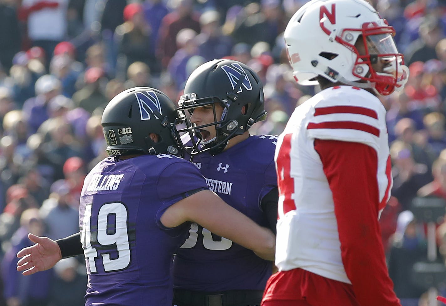 Northwestern's Drew Luckenbaugh, center, celebrates his game-winning field goal in overtime with teammate Jake Collins, left, next to Nebraska's Tre Neal in an NCAA college football game Saturday, Oct. 13, 2018, in Evanston, Ill.. (AP Photo/Jim Young)