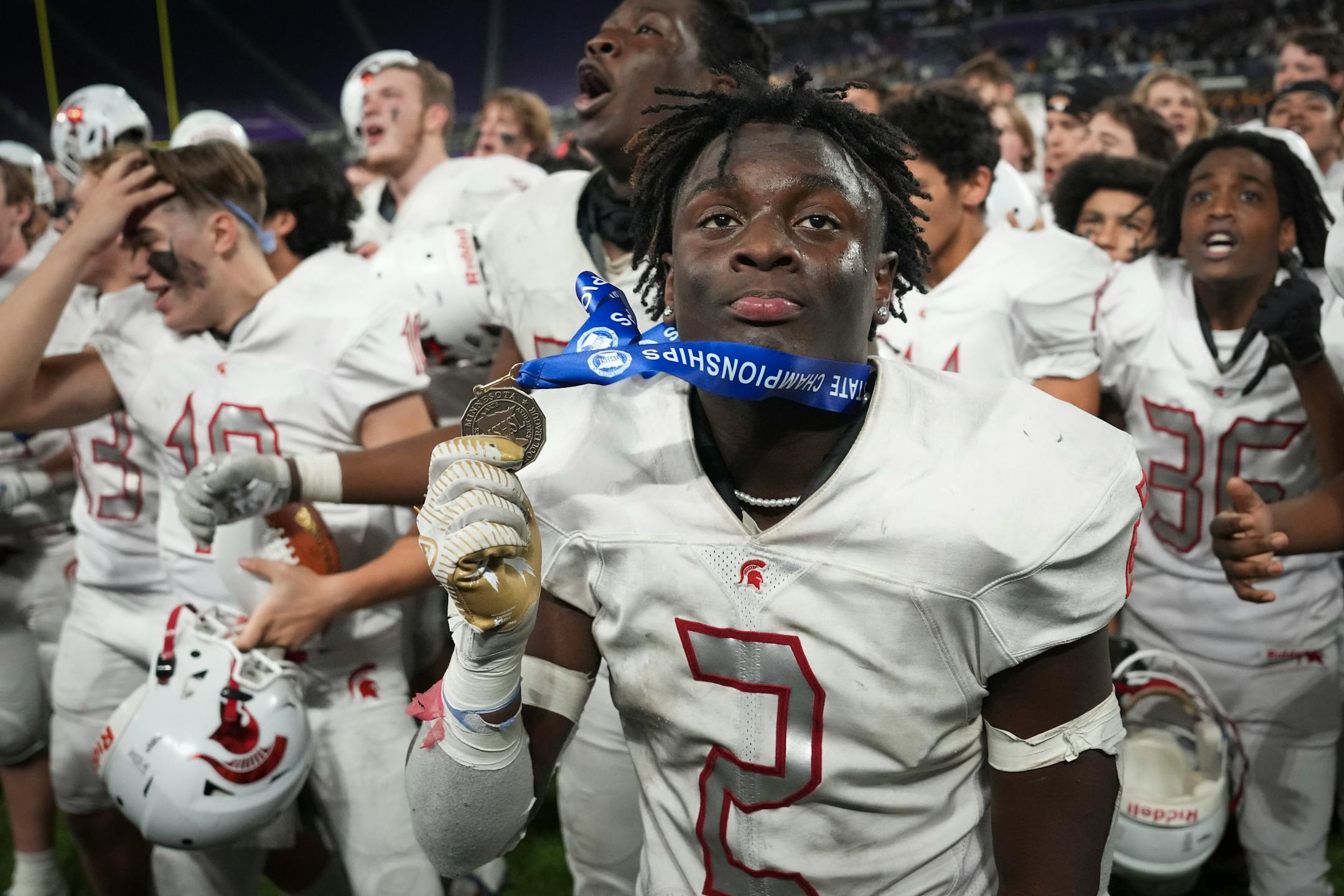 Simley Spartans teammates, led by Simley Spartans wide receiver Tay'vion McCoy (2) who caught an interception that ended game, ran to the fan section after winning the game.