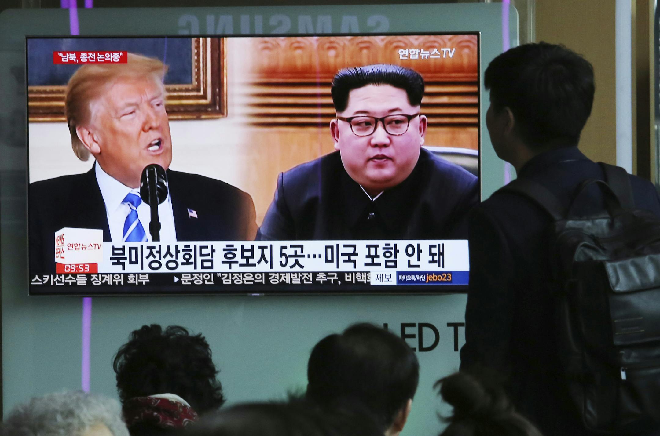 People watch a TV screen showing file footage of U.S. President Donald Trump, left, and North Korean leader Kim Jong Un during a news program at the Seoul Railway Station in Seoul, South Korea, Wednesday, April 18, 2018. Trump said Tuesday that the U.S. and North Korea are holding direct talks at "extremely high levels" in preparation for a potential summit with Kim. The signs read: " Five different locations for a summit meeting between the United States and North Korea." (AP Photo/Ahn Young-jo