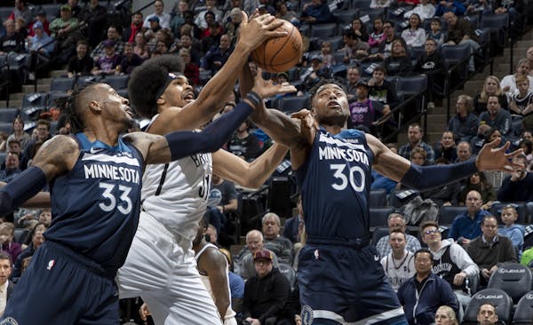 Jarrett Allen (31) on the Brooklyn Nets fought for the ball with Robert Covington (33) and Kelan Martin (30) of the Minnesota Timberwolves in the firs