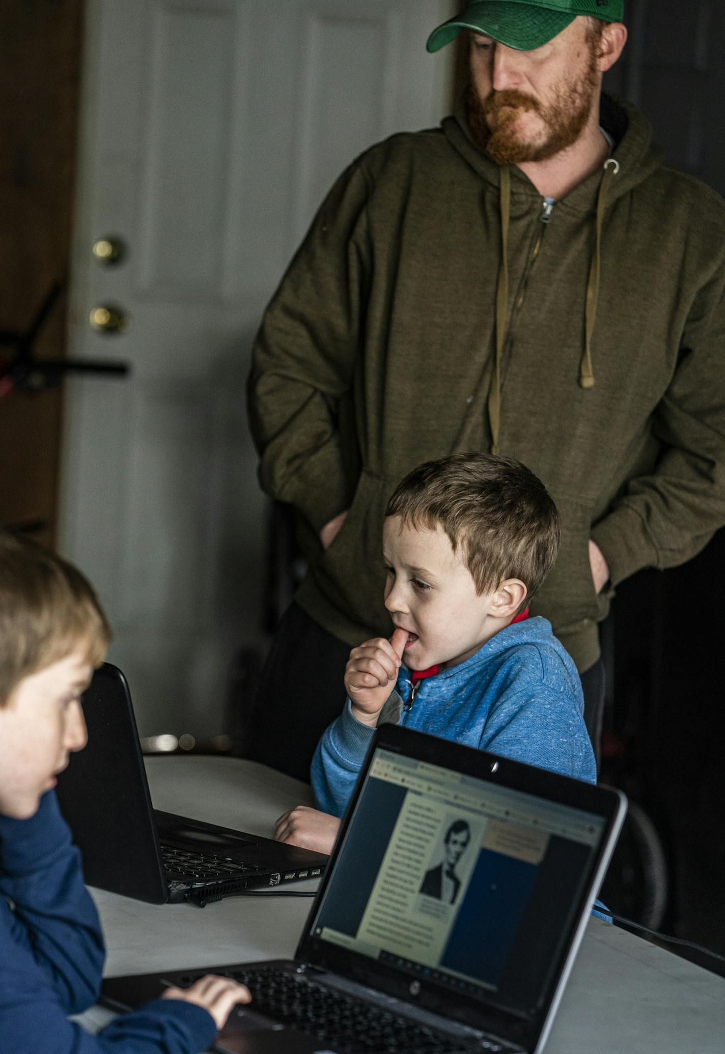 Dan Clapero works with son Franklin(6) on math addition while Calvin(9) reads. Mom is deployed in Kuwait. Her stay has been extended because of Covid-19.] RICHARD TSONG-TAATARII &#x2022; richard.tsong-taatarii@startribune.com