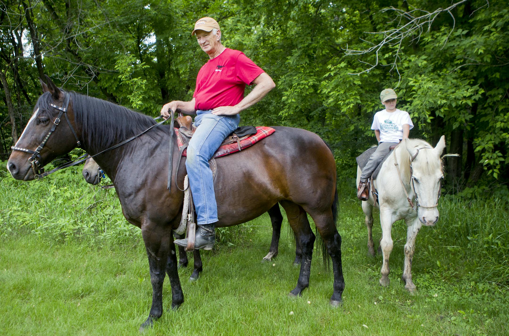 Lowell Murney, left, of Nowthen, and Louis Jones, 11, of Oak Grove, ride horseback along the banks of the Rum River in Anoka County on Monday, June 10, 2013. ] (ANNA REED/STAR TRIBUNE) anna.reed@startribune.com