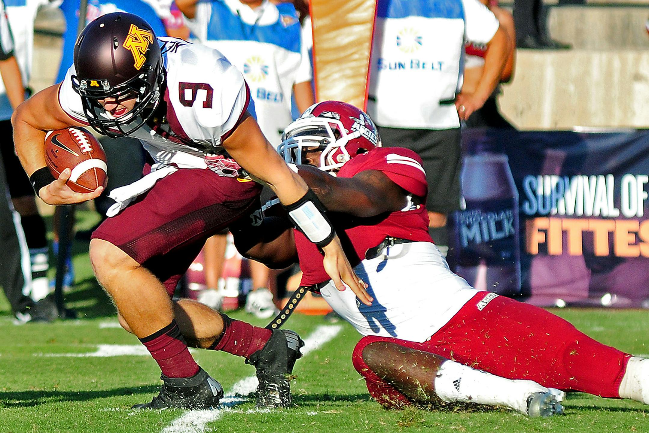 Philip Nelson runs a keeper as New Mexico State linebacker Trashaun Nixon attempts to break his stride during the first half of the game at Aggie Memorial Stadium in Las Cruces, N.M.