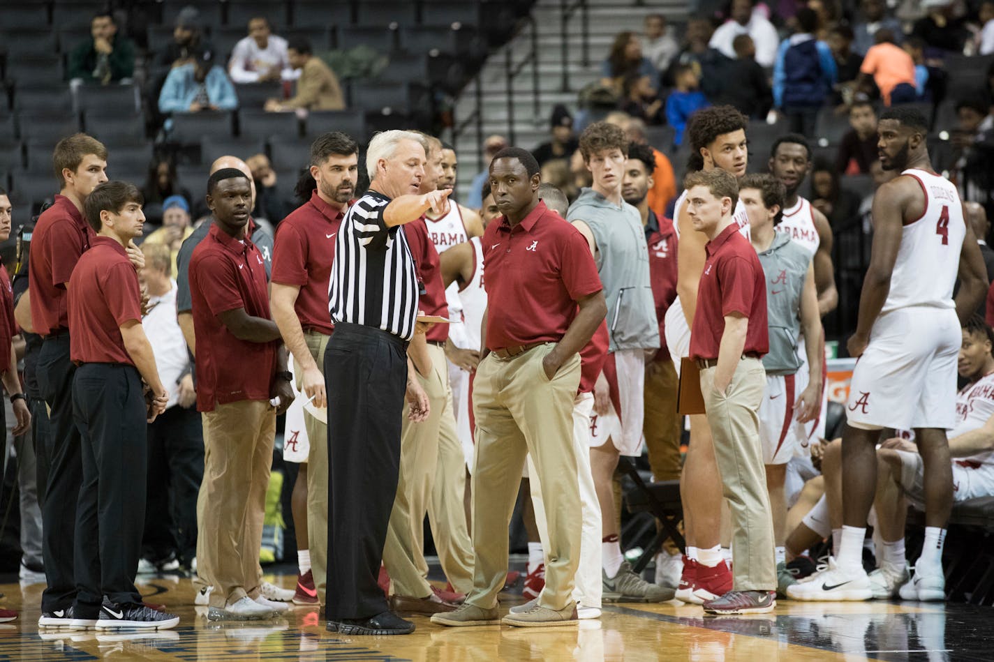 The referee speaks to Alabama head coach Avery Johnson after a fight broke out during the second half of an NCAA college basketball game against Minnesota, Saturday, Nov. 25, 2017, in New York. Minnesota won 89-84.(AP Photo/Mary Altaffer)