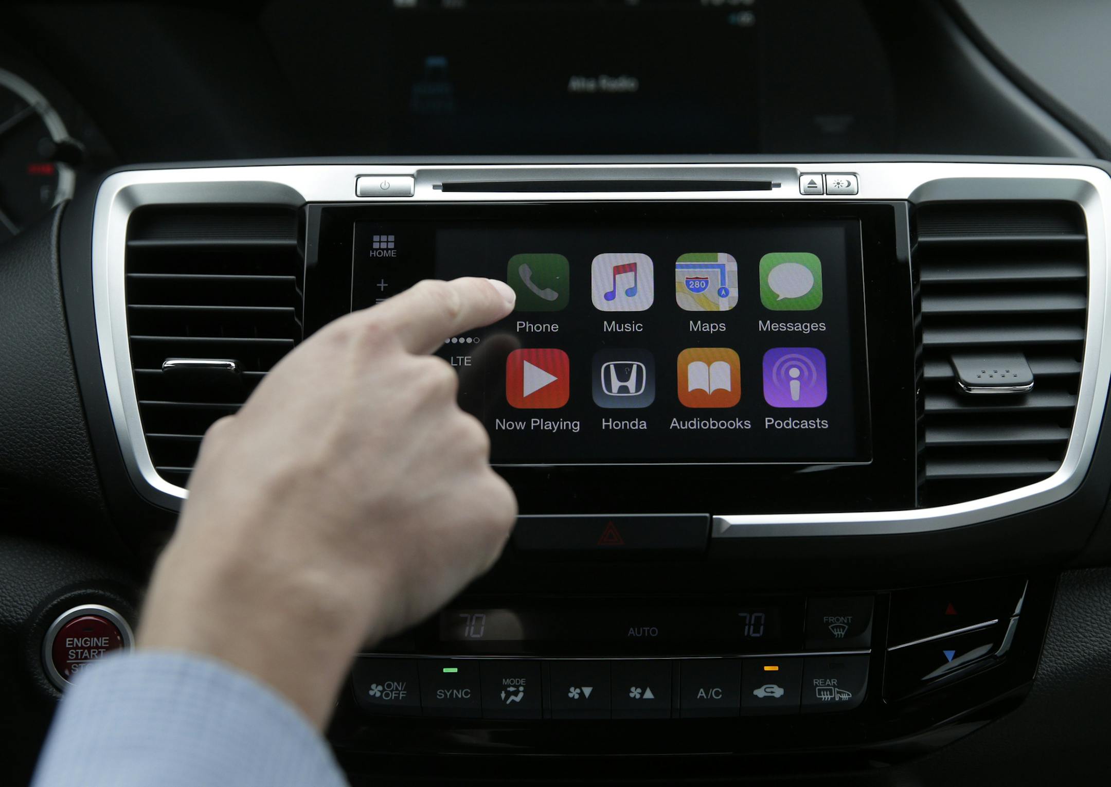 In this Thursday, Aug. 20, 2015 photo, Chris Martin from Honda North America demonstrates Apple CarPlay in Torrance, Calif. Playing deejay with voice commands will get easier for more Americans this fall as some best-selling cars get updated with software that integrates smartphones into the dashboard. (AP Photo/Jae C. Hong) ORG XMIT: NYBZ601